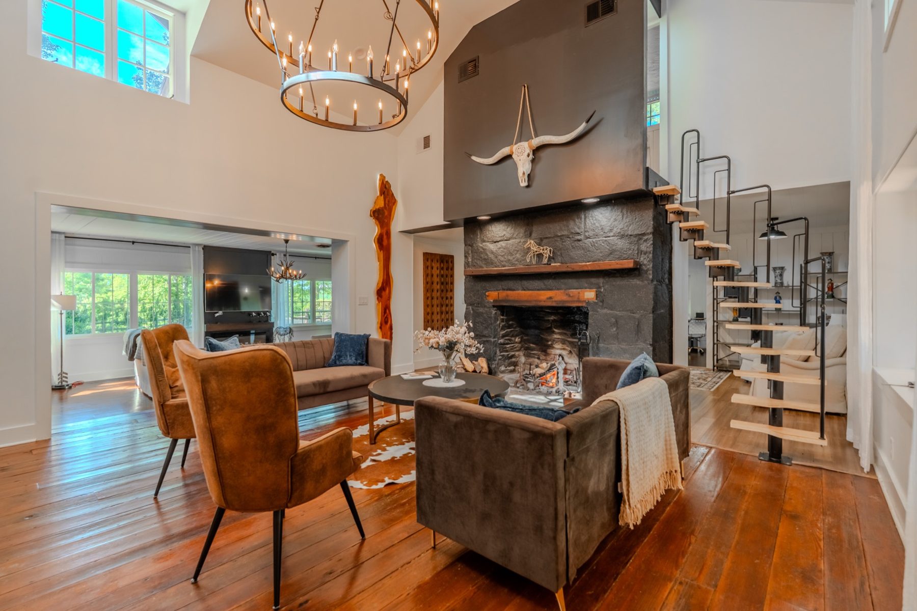 The great room at The Hayloft with its stone fireplace and open-riser staircase